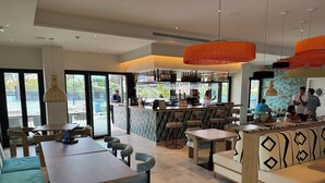A modern cafe with a bar area, seating arrangements, and large windows. - Al Fattah Luxury (Estepona)