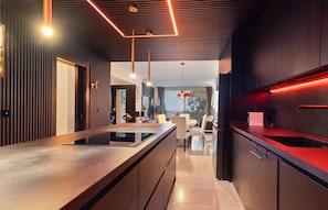 Una cocina moderna con una isla central, electrodomésticos integrados y un comedor con vistas.