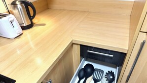 Eine Schublade mit Geschirr, einem Wasserkocher und einem Toaster.