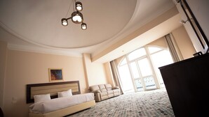 A hotel room with a bed, a sofa, a large window, and a chandelier. - oriental grand plaza (Tenth of Ramadan City)