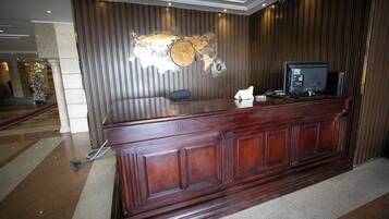 A reception desk with a world map, a clock, and a television.