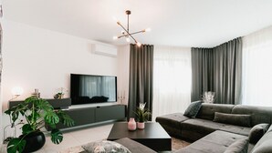 A modern living room with a grey sofa set, a flat-screen TV, a coffee table, and a potted plant. - Villa Felicity B4 (Sibenik)