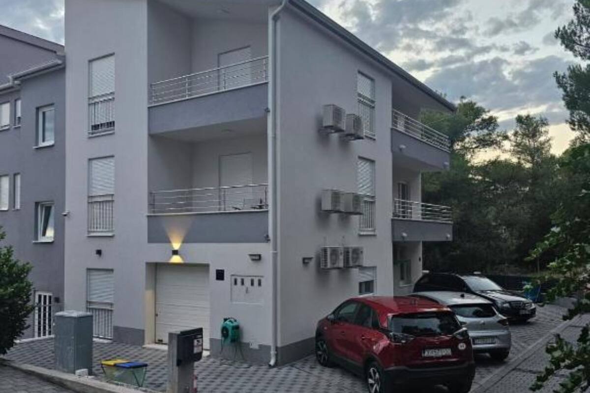 A multi-story residential building with a parking area.