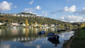 A calm river with boats, a hillside with houses, and a clear sky. - Apartment in Vallendar Near Rhine Promenade (Vallendar)