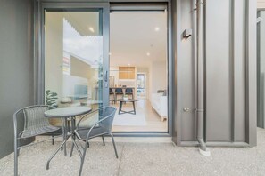 Ein modernes Interieur mit einer Glastür, die in einen Essbereich mit Tisch und Stühlen führt.