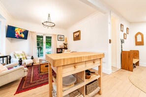 Een ruime woonkamer met een houten tafel, een bank en een televisie.
