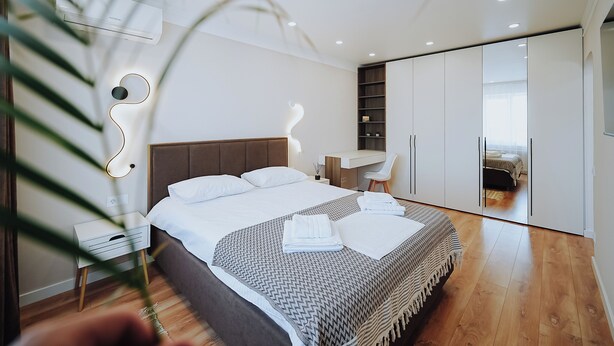 Une chambre moderne avec un grand lit, un bureau et une armoire.