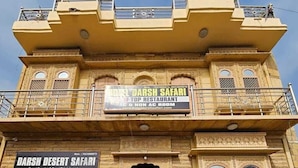 A building with signs for Darsh Desert Safari and Desert Camping & Camel Ride Information.