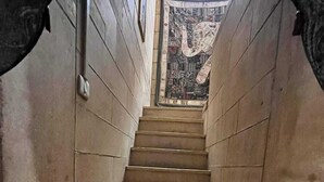A narrow staircase with a patterned wall at the top.