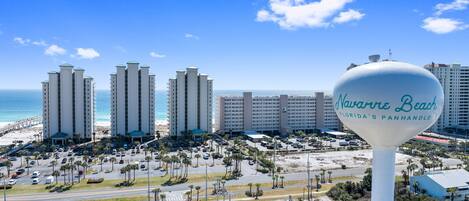 A view of a beachside hotel with a large sign reading "Navasero Beach Florida's Panhandle".
