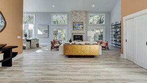 A spacious living room with a large wooden coffee table, comfortable seating, a fireplace, and a bookshelf. - Sunset Rentals | Red Oak 40 (Hilton Head Island)