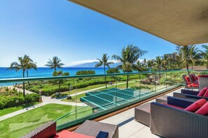 Un balcon avec vue sur l’océan, un espace salon extérieur et un coin piscine.