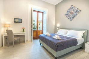 A bedroom with a bed, a desk, a chair, a nightstand, and a door leading to a balcony. - Maramia Luxury Apartment (Sant'Agnello)