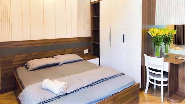 Ein modernes Schlafzimmer mit Bett, Nachttischen, Schreibtisch und Stuhl.