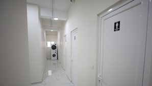 Chuveiro, toalhas de banho, shampoo, papel higiênico