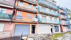 Un immeuble résidentiel à plusieurs étages, doté de balcons, dont certains sont pourvus de garde-corps et d’autres de climatiseurs.