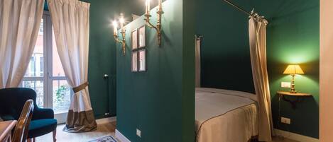 A room with a bed, a chair, a lamp, and a window with curtains.