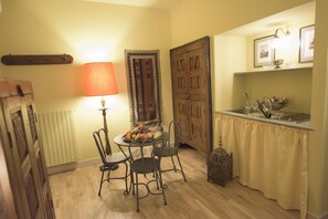 A dining area with a table set for four, a lamp, and a decorative door. - Porta Palace Apartments (Turin)