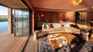 Une chambre spacieuse avec un grand lit, un plancher en bois et une vue sur un lac.