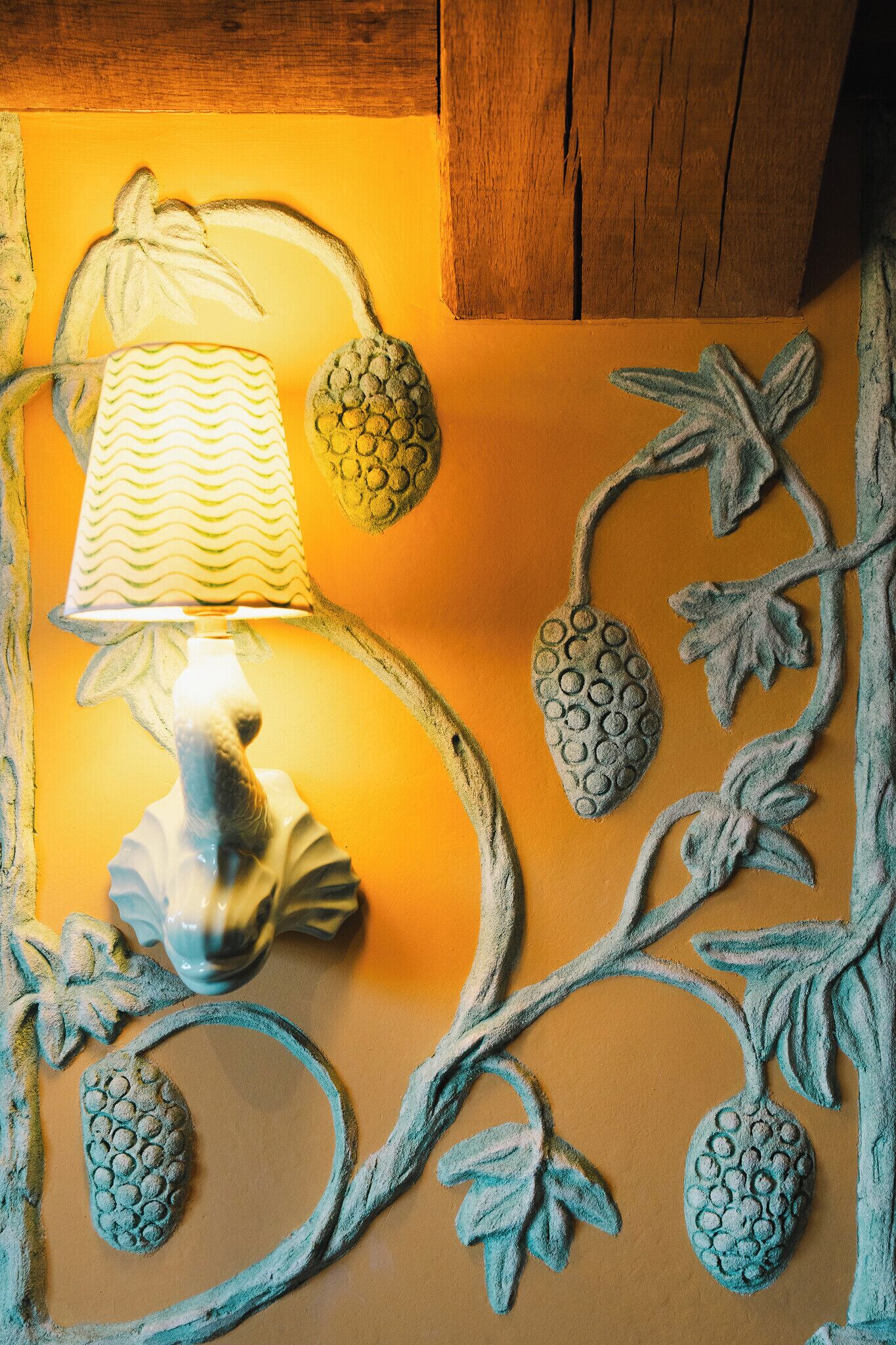 Una pared con una lámpara decorativa y motivos de piña.