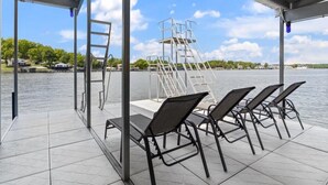 Un espace extérieur abrité comprenant une plateforme de plongeon, des chaises et une échelle.