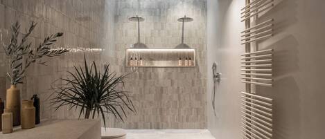 Une salle de bain moderne équipée d’une douche, d’un meuble-lavabo et d’un porte-serviettes.