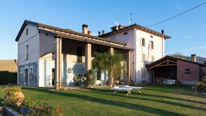 A two-story house with a covered patio and a lawn. - CASA DELLE VIOLE (Fornovo di Taro)