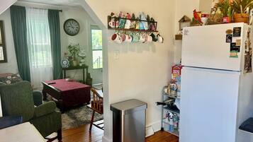 Un espacio habitable compacto con kitchenette, comedor y una pequeña zona de estar.