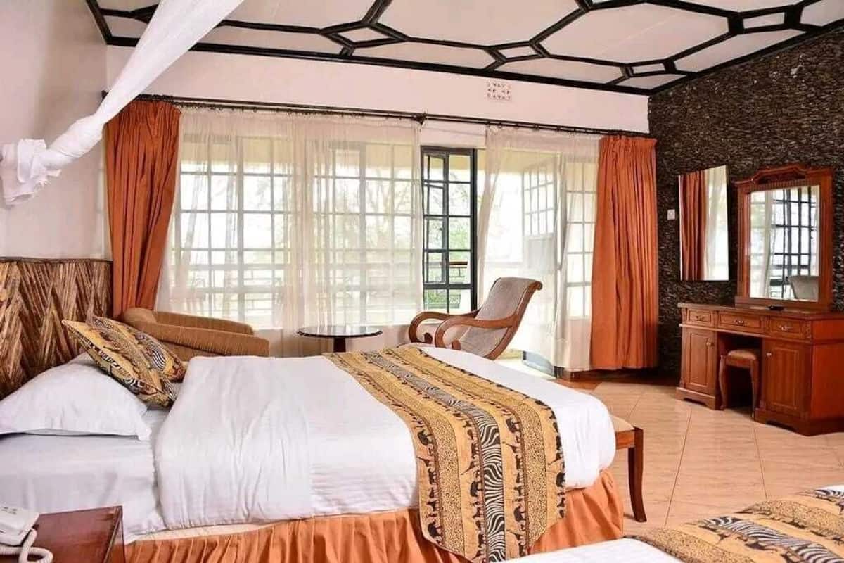 A well-appointed bedroom with a large bed, a wooden desk, and a chair.
