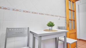 Un coin repas avec une table, des chaises et une plante en pot.