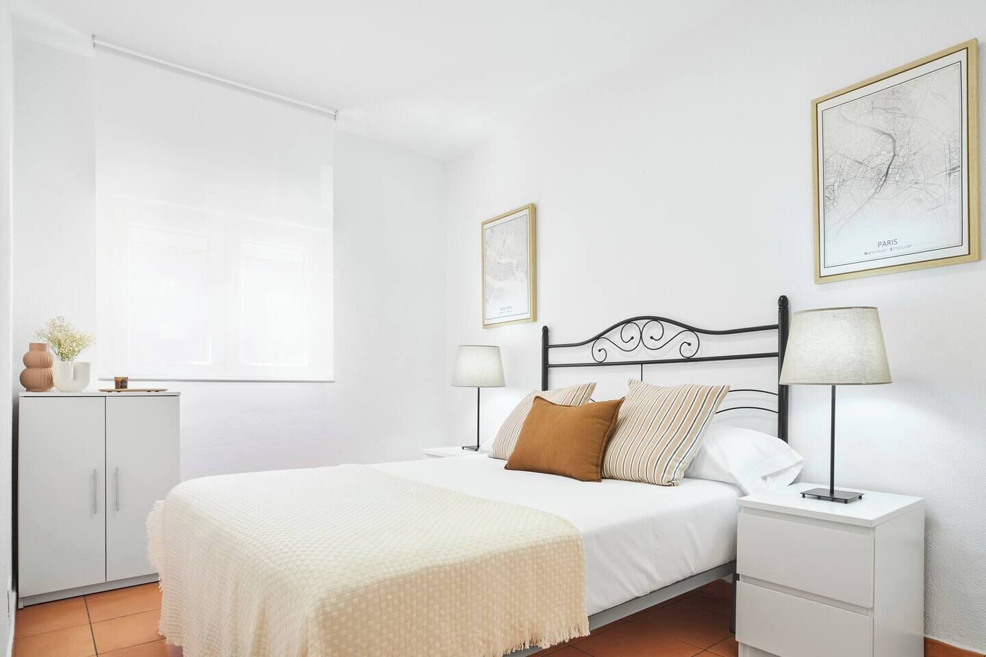 Un dormitorio con cama, mesitas de noche, armario y ventana.