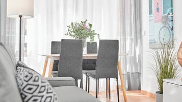 Una sala de estar moderna con sofá, mesa de comedor, sillas y una lámpara.