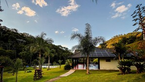 Un jardin bien entretenu, avec un chemin menant à un bâtiment équipé de panneaux solaires.