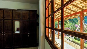 Une pièce avec une grande armoire en bois et une fenêtre donnant sur un jardin.