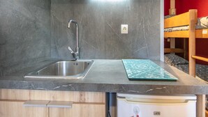 A compact kitchen with a stainless steel sink, a microwave, and a built-in dishwasher. - Studio in Chamrousse Near Ski Resort (Chamrousse)