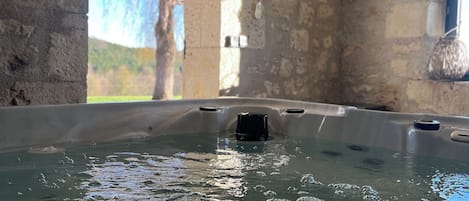 Relax in a hot tub with a view of the outdoors.