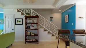 Eine Treppe mit weißer Geländer, ein Holzregal und eine blaue Akzentwand.