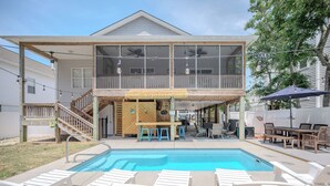 A two-story house with a pool, outdoor bar, and seating area. - Sandy Toes Bungalow: Dog-Friendly with Private Pool (Oak Island)