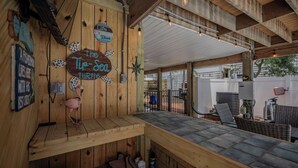 A wooden interior with a sign reading 'The Tip-Sed Turtle,' a wooden bench, and a table with chairs. - Sandy Toes Bungalow: Dog-Friendly with Private Pool (Oak Island)