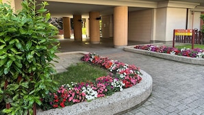 Une cour intérieure avec un jardin central, entourée de colonnes et d’une galerie couverte.