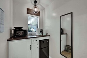 A compact kitchen with white cabinets, a black refrigerator, a microwave, and a coffee maker. - Casa Salvia Tejas Suite Walking Distance to MainSt! (Fredericksburg)