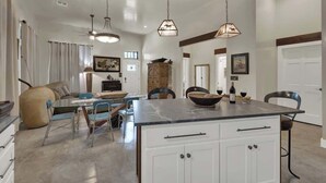 A spacious living area with a large island, dining table, and modern furniture.