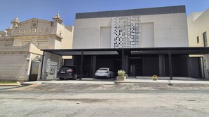 Un bâtiment moderne doté d’une entrée abritée et d’un espace de stationnement.