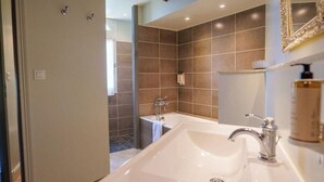A modern bathroom with a large sink, a bathtub, and a shower area. - Les Suites Du Cha Teau (Candes-Saint-Martin)