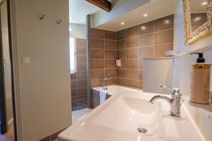 Ein modernes Badezimmer mit einem großen Waschbecken, einer Badewanne und einer Duschkabine.