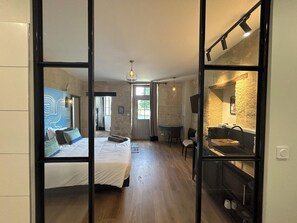 Una habitación con cama, escritorio, silla y chimenea.
