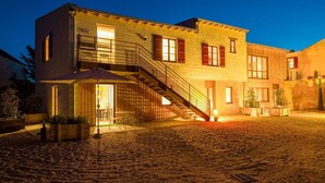 A two-story building with a staircase leading to the upper floor, outdoor seating area, and a paved courtyard. - Les Suites Du Cha Teau (Candes-Saint-Martin)