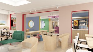 A modern interior with a dining area, a green sofa, and a kitchen with fruit display. - Unisotel (Bron)