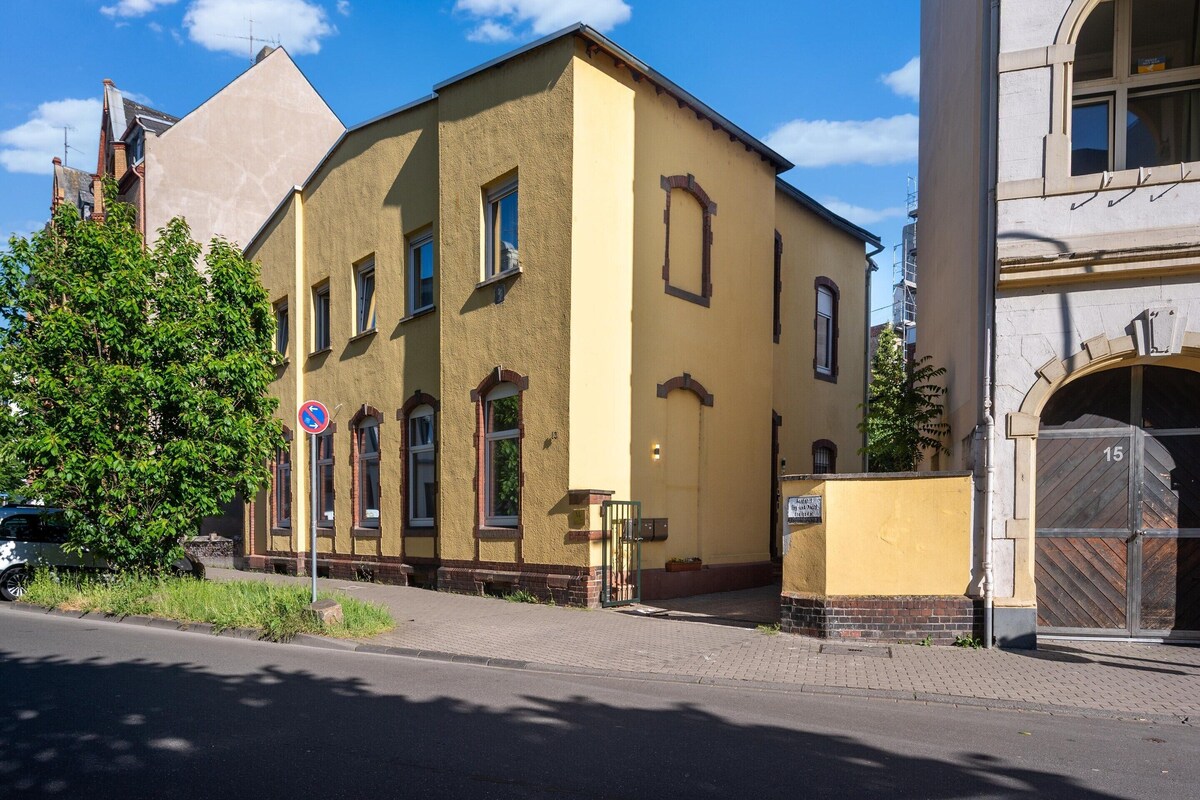 A yellow building with a brick base and multiple windows.