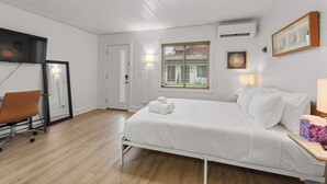 A bedroom with a bed, a desk, and a chair. - Chic City Retreat 93J For 2! (Columbus)